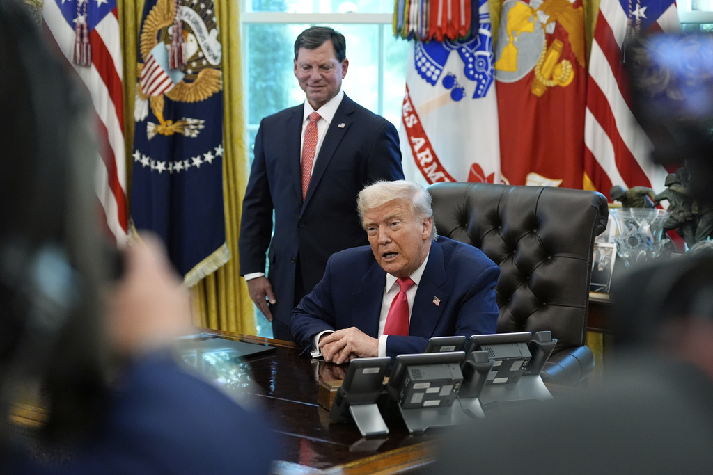 President Donald Trump speaks with reporters as Social Security Commissioner Frank Bisignano listens during an event in the Oval Office to mark the 90th anniversary of the Social Security Act, Thursday, Aug. 14, 2025, in Washington. (AP Photo/Alex Brandon)
