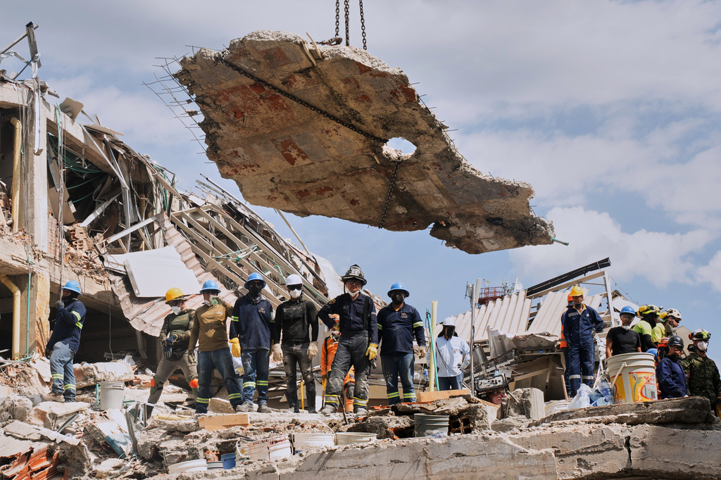 A crane lifts a concrete slab to clear the way for rescuers searching through the rubble three days after an earthquake hit Pereira, Colombia, Thursday, Aug. 13, 2026. (AP Photo/Brandon Pinto)