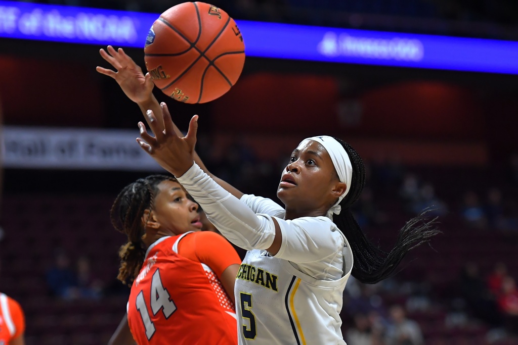 Michigan guard Brooke Q. Daniels (5) reaches for the ball in front of Syracuse guard Shy Hawkins (14) in the first half of an NCAA college basketball game, Sunday, Nov. 23, 2025, in Uncasville, Conn. (AP Photo/Steven Senne)