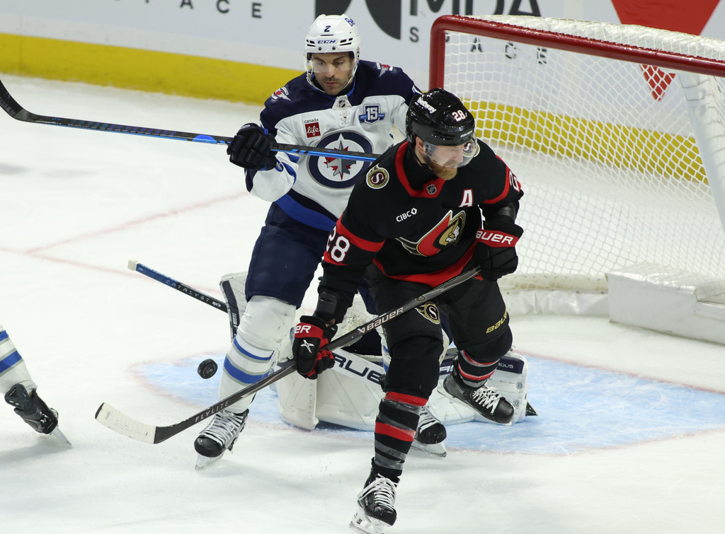 Winnipeg Jets' Dylan DeMelo (2) and Ottawa Senators' Claude Giroux (28) battle in front of the net during the second period of an NHL hockey game in Ottawa, Ontario, on Saturday, Jan. 3, 2026. (Patrick Doyle/The Canadian Press via AP)