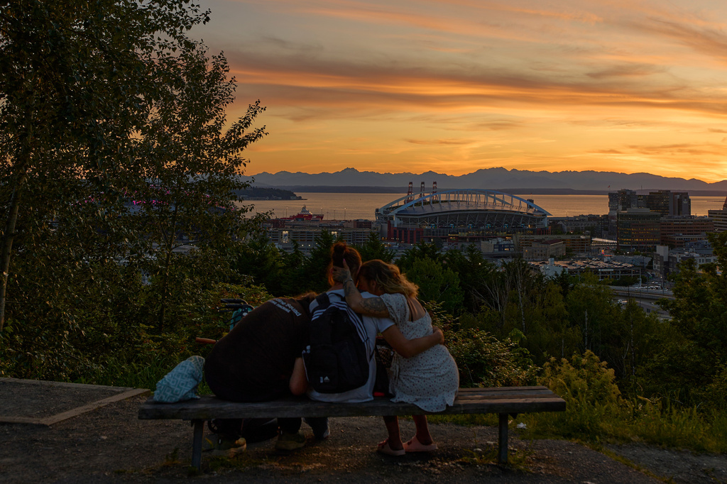 FILE - Soccer fans sit on a bench overlooking Lumen Field stadium at sunset during the 2026 World Cup in Seattle, Saturday, June 13, 2026. (AP Photo/Manu Fernandez, File)