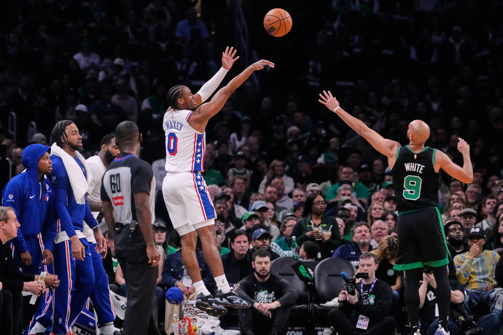 Philadelphia 76ers guard Tyrese Maxey (0) takes a 3-point shot over Boston Celtics guard Derrick White (9) during the first half of Game 5 of a first-round NBA playoffs basketball series, Tuesday, April 28, 2026, in Boston. (AP Photo/Charles Krupa)