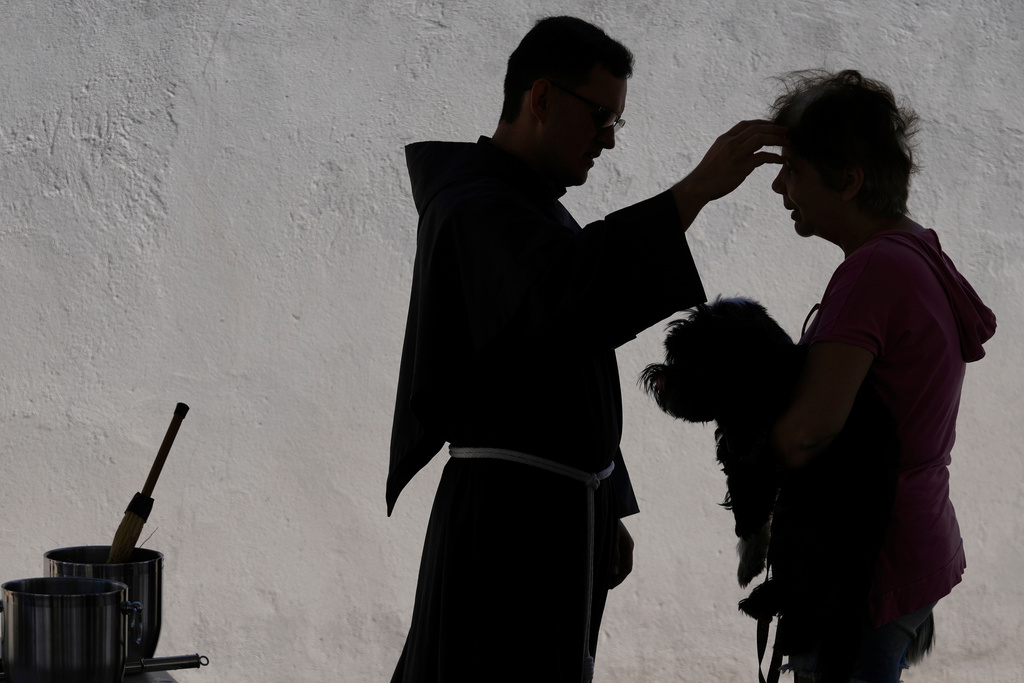FILE - A priest blesses animals during a Mass in honor of Saint Francis of Assisi, considered the protector of animals, on the Saint's feast day, in Brasilia, Brazil, Saturday, Oct. 4, 2025. (AP Photo/Eraldo Peres, File)