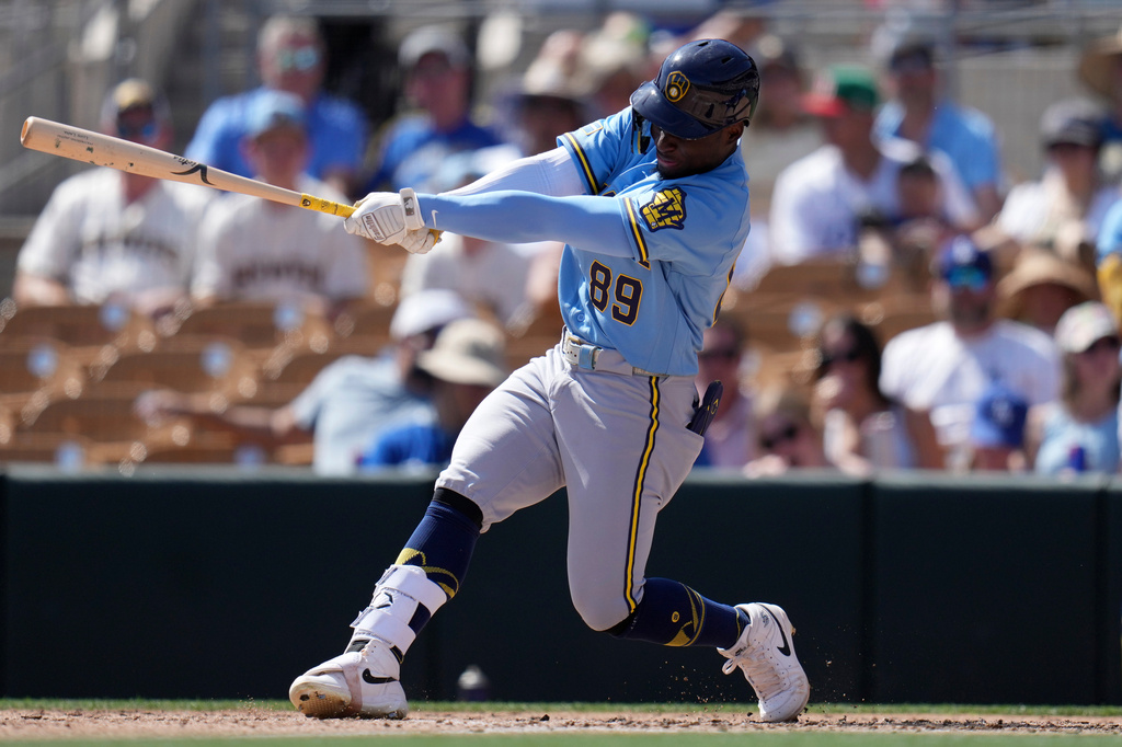 FILE - Milwaukee Brewers' Luis Lara follows through with his swing against the Los Angeles Dodgers during the third inning of a spring training baseball game, Monday, March 16, 2026, in Phoenix. (AP Photo/Ross D. Franklin,File)