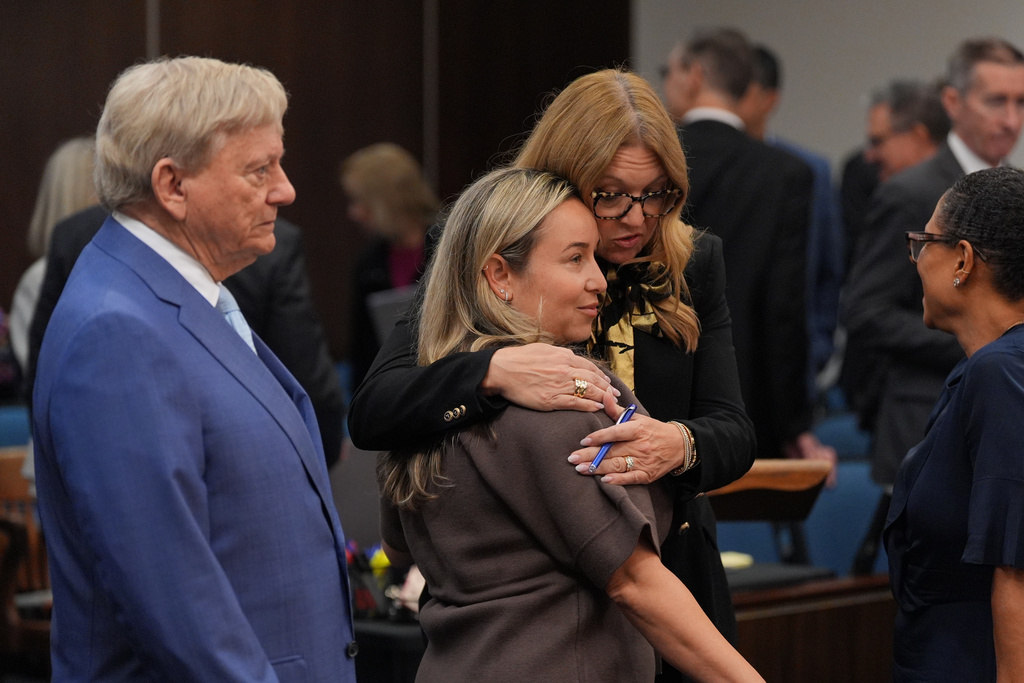 Carli Skaggs, widow of pitcher Tyler Skaggs, center, is embraced by attorney Lara Hollingsworth as attorney Rusty Hardin looks on before opening statements in the trial for the wrongful death lawsuit accusing the Los Angeles Angels baseball team of being responsible for the 2019 drug overdose death Skaggs Tuesday, Oct. 14, 2025, in Santa Ana, Calif. (AP Photo/Jae C. Hong, Pool)