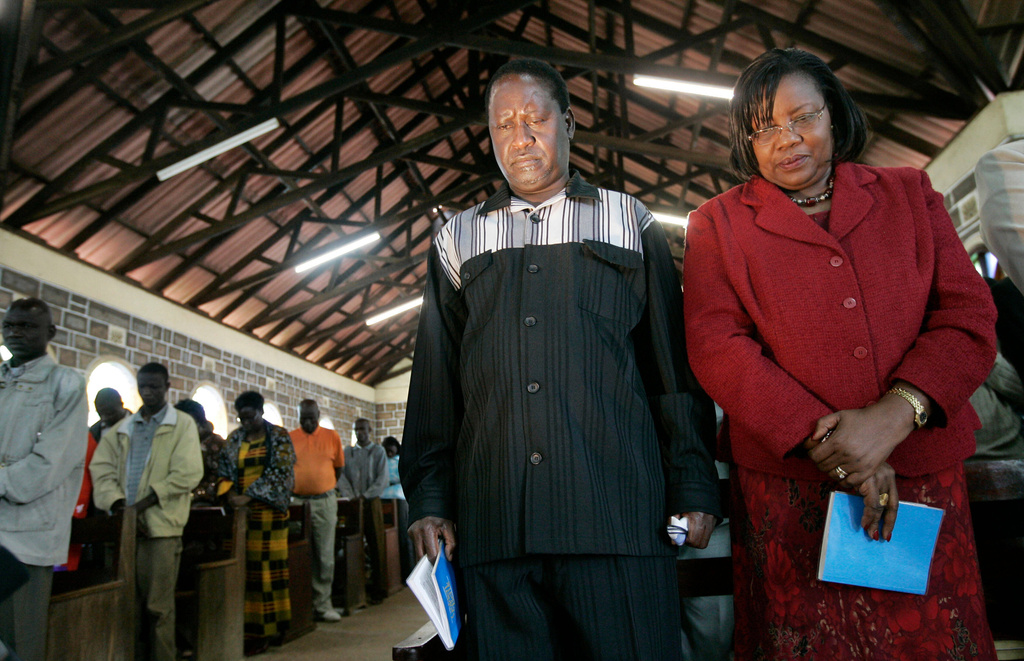 Kenyan opposition leader Raila Odinga. center, and his wife Ida, right, attend a Sunday service at the Holy Trinity Church in Kibera slum, Nairobi, Kenya, Sunday, Jan. 20, 2008. (AP Photo/Ben Curtis)