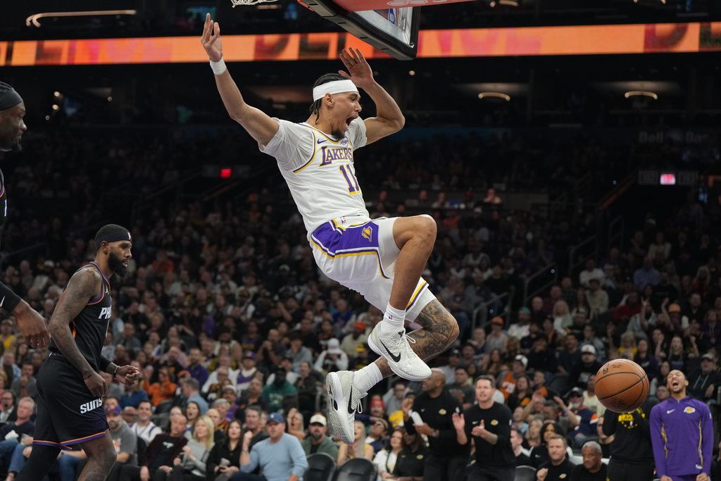 Los Angeles Lakers center Jaxson Hayes, center, reacts after dunking against the Phoenix Suns during the first half of an NBA basketball game, Sunday, Dec. 14, 2025, in Phoenix. (AP Photo/Rick Scuteri)