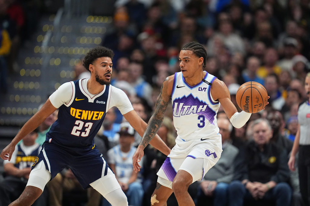 Utah Jazz guard Keyonte George, right, drives to the basket as Denver Nuggets forward Cameron Johnson, left, defends in the first half of an NBA basketball game Monday, Dec. 22, 2025, in Denver. (AP Photo/David Zalubowski)
