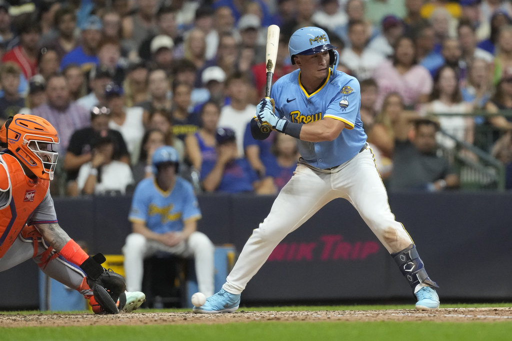 Milwaukee Brewers' Isaac Collins, right, is hit by a pitch with the bases loaded to drive in a run during the fifth inning of a baseball game against the New York Mets, Friday, Aug. 8, 2025, in Milwaukee. (AP Photo/Aaron Gash)
