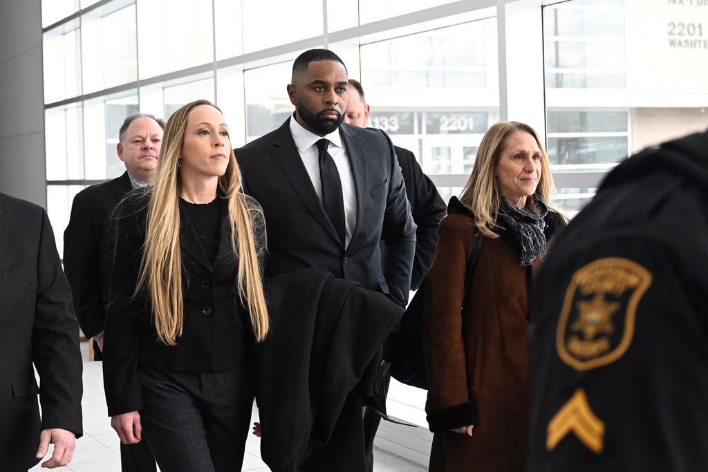 Former Michigan football coach Sherrone Moore, second from right, walks with his wife, Kelli Moore, left, and his attorney, Ellen K. Michaels, right, towards the courtroom, Thursday, Jan. 22, 2026, in Ann Arbor, Mich. (AP Photo/Jose Juarez)