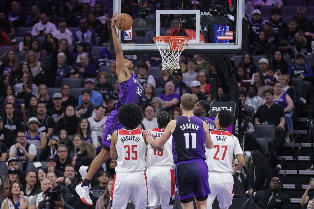 Sacramento Kings center Dylan Cardwell (32) goes yup to dunk during the first half of an NBA basketball game against the Washington Wizards, Friday, Jan. 16, 2026, in Sacramento, Calif. (AP Photo/Scott Marshall)