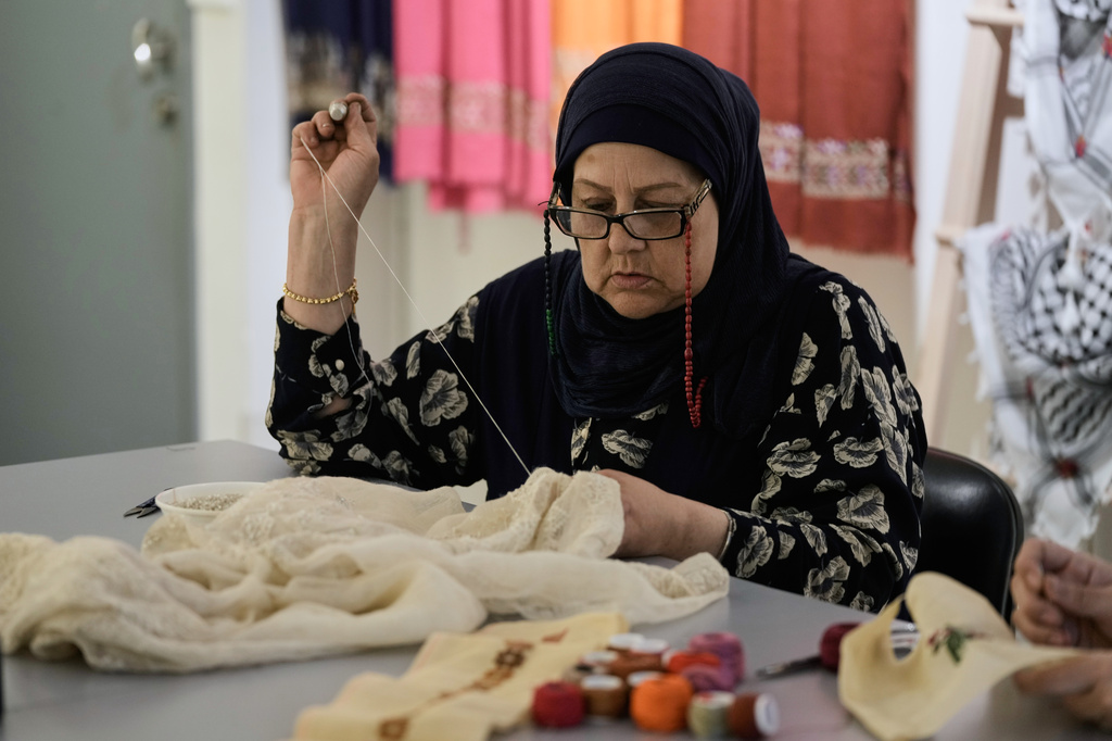 Palestinian weaver Samira Nasser works on a handmade embroidered piece at the Inaash Association embroidery workshop in Beirut, Tuesday, May 19, 2026. (AP Photo/Bilal Hussein)