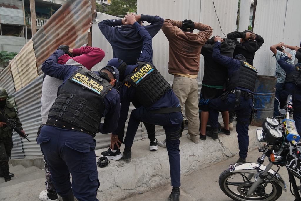 Police officers frisk men during the country's state of emergency, following an escalation of gang-related violence, on the outskirts of Guatemala City, Tuesday, Jan. 20, 2026. (AP Photo/Moises Castillo)