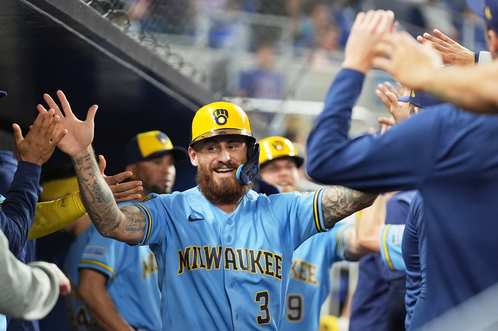 Milwaukee Brewers' Joey Ortiz (3) is high-fived in the dugout after scoring on a double hit by Garrett Mitchell during the tenth inning of a baseball game, Friday, April 17, 2026, in Miami. (AP Photo/Lynne Sladky)