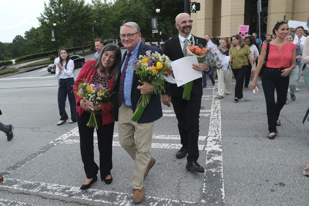 Dr. Debra Houry, left, Dr. Daniel Jernigan and Dr. Demetre Daskalakis gather as workers and supporters rally for departing scientific leaders at the Centers for Disease Control and Prevention outside the CDC headquarters, Thursday, Aug. 28, 2025, in Atlanta. (AP Photo/Ben Gray)