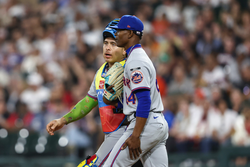 New York Mets pitcher Jefry Yan, right, and catcher Francisco Alvarez, left, interact while walking toward the mound during the ninth inning of a baseball game against the Chicago White Sox in Chicago, Friday, Aug. 21, 2026. (AP Photo/Jessie Alcheh)