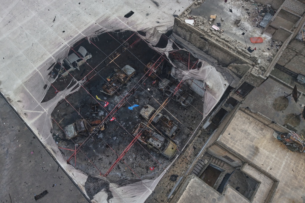 FILE - An aerial view shows destroyed vehicles in a building in the area of the predominantly Kurdish Sheikh Maqsoud neighborhood where clashes broke out Tuesday Jan. 6 between government forces and the Kurdish-led Syrian Democratic Forces in the northern city of Aleppo, Syria, Monday, Jan. 12, 2026. (AP Photo/Omar Albam)