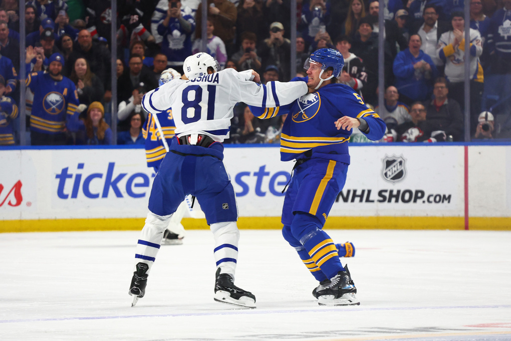 Toronto Maple Leafs center Dakota Joshua (81) and Buffalo Sabres defenseman Luke Schenn (5) fight during the first period of an NHL hockey game Saturday, March 14, 2026, in Buffalo, N.Y. (AP Photo/Jeffrey T. Barnes)