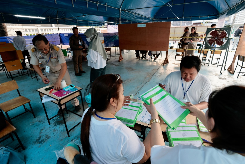 CORRECTS DATE TO 8, NOT 7 - Police officers and election volunteers prepare for the general election at a voting station in Bangkok, on Sunday, Feb. 8, 2026. (AP Photo/Wason Wanichakorn)