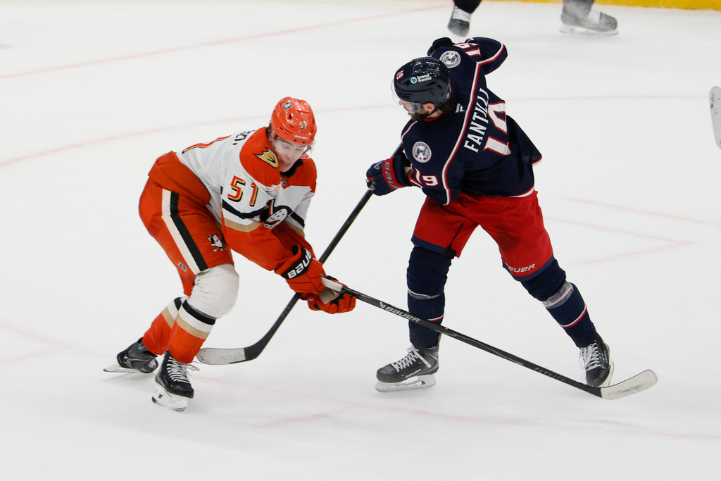 Columbus Blue Jackets' Adam Fantilli, right, shoots past Anaheim Ducks' Olen Zellweger to score during the overtime period of an NHL hockey game, Tuesday, Dec. 16, 2025, in Columbus, Ohio. (AP Photo/Jay LaPrete)