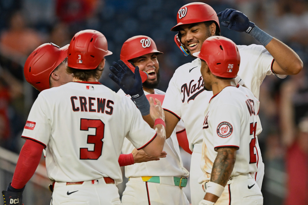 Washington Nationals' James Wood is greeted at home plate by his teammates after hitting a grand slam during the fifth inning of a baseball game against the Houston Astros, Monday, July 6, 2026, in Washington. (AP Photo/John McDonnell)