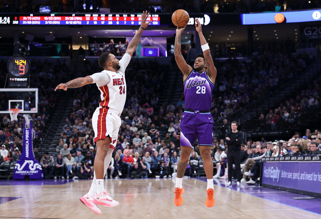 Utah Jazz forward Brice Sensabaugh (28) shots a three point basket over Miami Heat guard Norman Powell (24) during the second half of an NBA basketball game, Saturday, Jan. 24, 2026, in Salt Lake City. (AP Photo/Rob Gray)