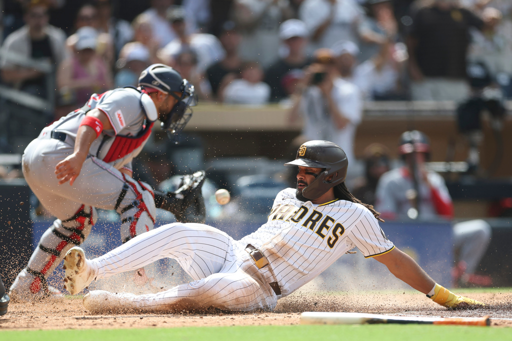 San Diego Padres' Fernando Tatis Jr., right, scores on Manny Machado's RBI single in the third inning of a baseball game against the Washington Nationals, Monday, Sept. 7, 2026, in San Diego. (AP Photo/Karl Anderson)