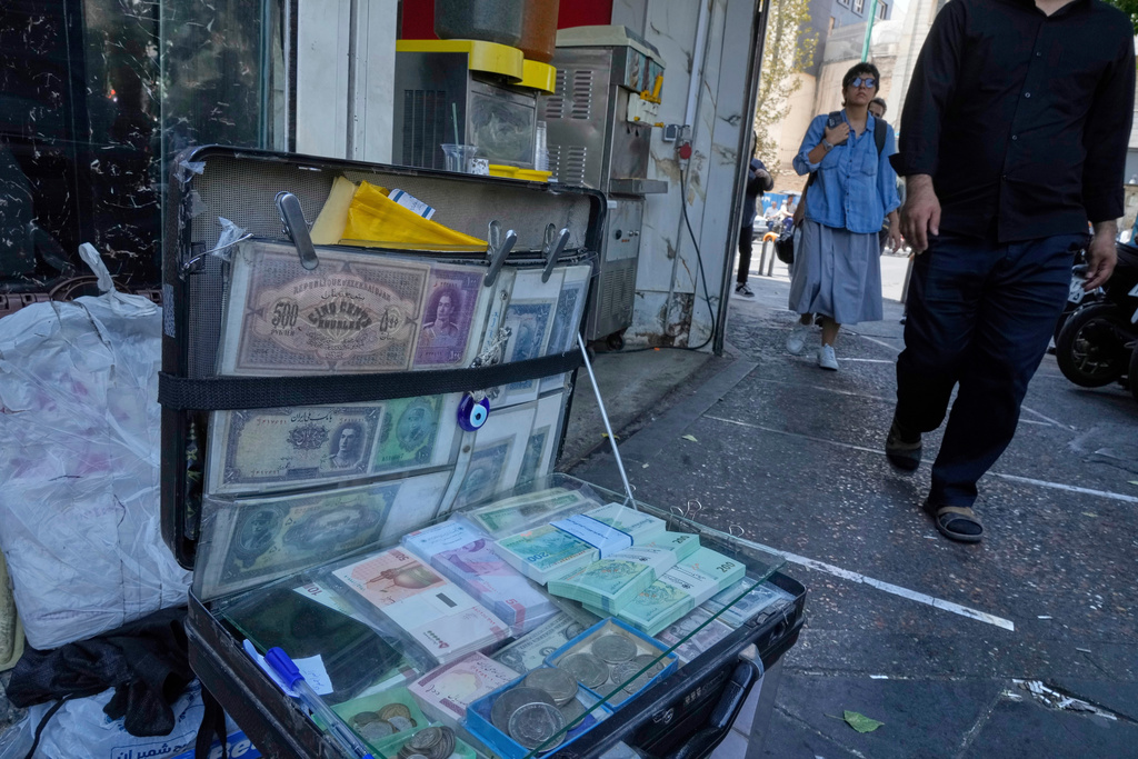 FILE - Current and pre-revolution Iranian banknotes are displayed by a street money exchanger at Ferdowsi square, Tehran's go-to venue for foreign currency exchange, in downtown Tehran, Iran, on Aug. 28, 2025. (AP Photo/Vahid Salemi, File)