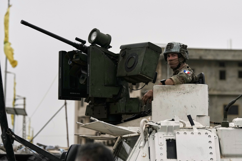 A French U.N peacekeeper sits on an armored personnel carrier at a road used by displaced people to return to their villages on the second day of a ceasefire between Hezbollah and Israel in Qasmiyeh, near Tyre city, southern Lebanon, Saturday, April 18, 2026. (AP Photo/Bilal Hussein)