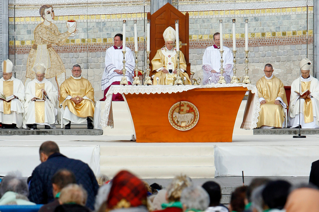 FILE - Pope Benedict XVI, center, celebrates a Mass in front of the Basilica of the Rosary in Lourdes, southwestern France, on Sept. 15, 2008. Behind him is one of the mosaics by Rev. Marko Ivan Rupnik, who was declared excommunicated in 2020 for committing one of the worst crimes in church law – using the confessional to absolve a woman with whom he had engaged in sexual activity. (AP Photo/Alessandra Tarantino, File)