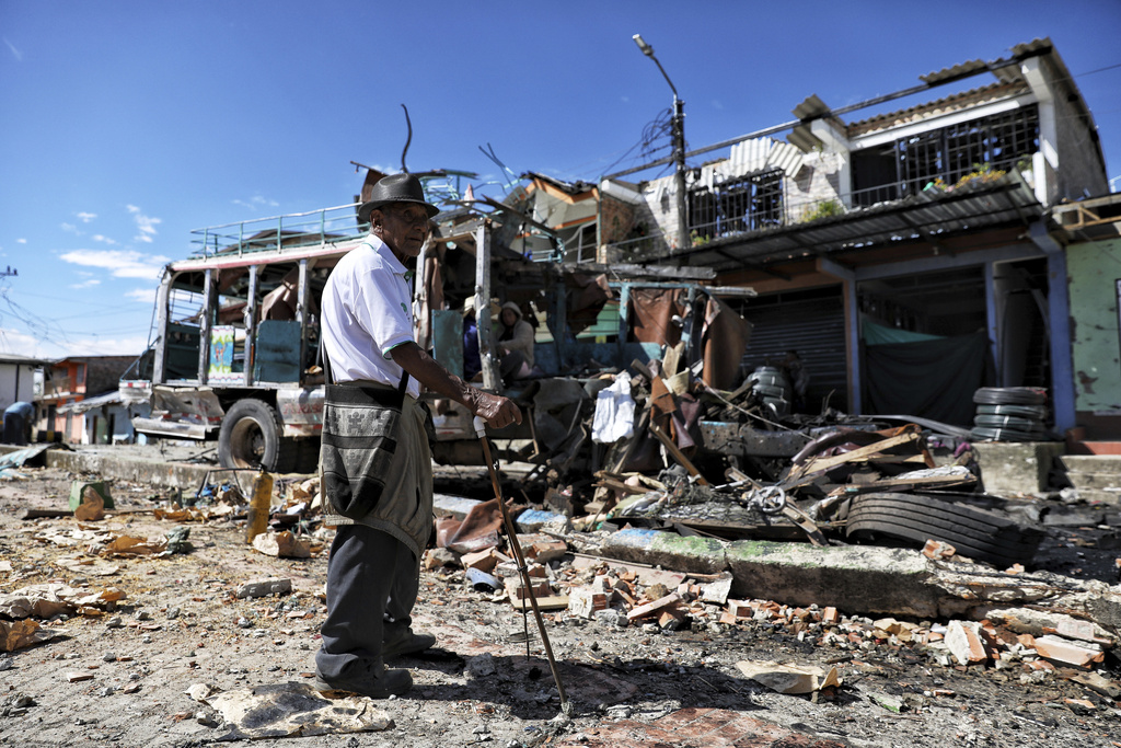A resident stands in front of the police station in El Carmelo, Colombia, a day after a deadly attack that authorities blame on a dissident faction of the demobilized Revolutionary Armed Forces of Colombia, or FARC, Monday, Sept. 15, 2025.. (AP Photo/Santiago Saldarriaga)