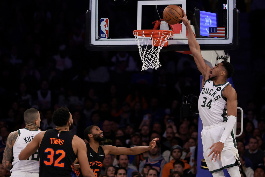 Milwaukee Bucks forward Giannis Antetokounmpo (34) dunks the ball over New York Knicks guard Mikal Bridges during the second half of an NBA Cup basketball game, Friday, Nov. 28, 2025, in New York. (AP Photo/Adam Hunger)