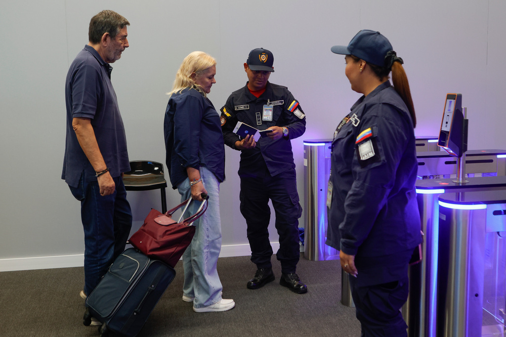Departing passengers stand at security inside Simon Bolivar International Airport as it reopens to commercial flights two months after closing due to the earthquake in Maiquetia, Venezuela, Tuesday, Sept. 1, 2026. (AP Photo/Pedro Mattey)