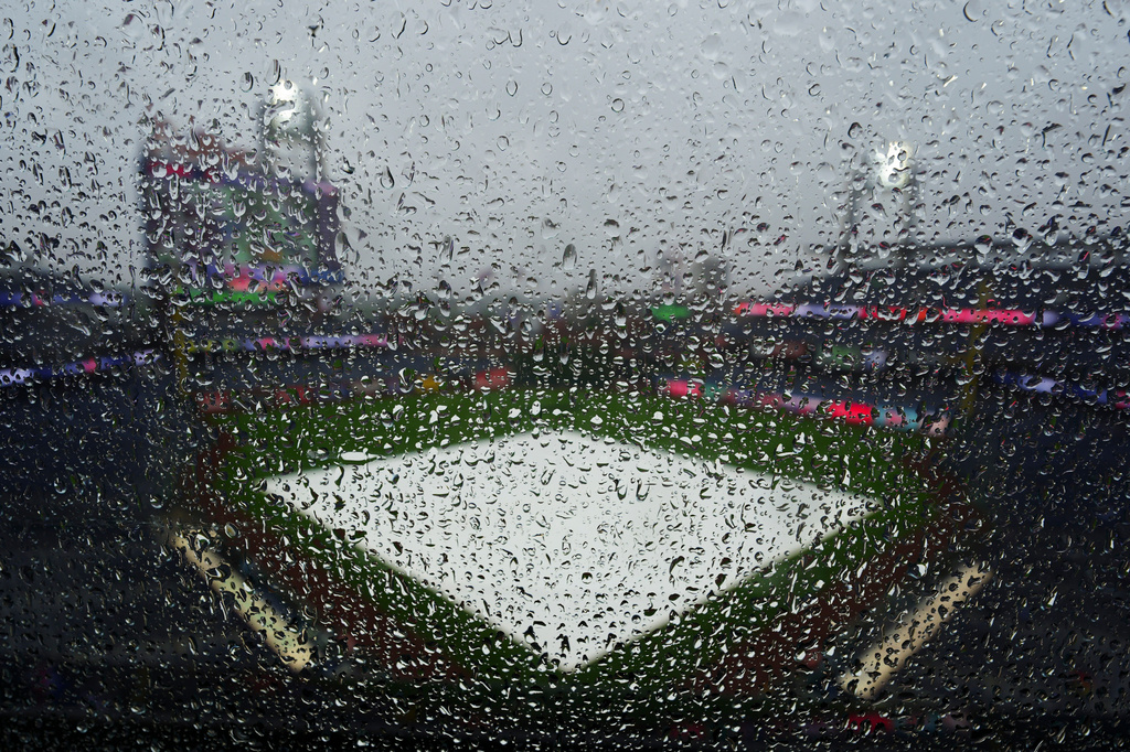 Rain water collects on glass prior to the start of a baseball game between the Philadelphia Phillies and the Cleveland Guardians, Saturday, May 23, 2026, in Philadelphia. (AP Photo/Derik Hamilton)