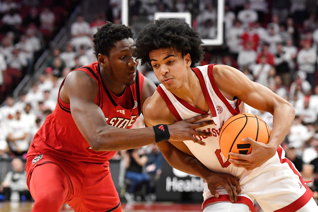 Louisville guard Mikel Brown Jr., right, attempts to get past North Carolina State guard Tre Holloman, left, during the second half of an NCAA college basketball game in Louisville, Ky., Monday, Feb. 9, 2026. (AP Photo/Timothy D. Easley)