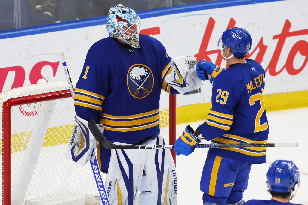 Buffalo Sabres goaltender Ukko-Pekka Luukkonen (1) and left wing Beck Malenstyn (29) celebrate a 4-1 victory following the third period of an NHL hockey game against the Carolina Hurricanes, Sunday, Nov. 23, 2025, in Buffalo, N.Y. (AP Photo/Jeffrey T. Barnes)