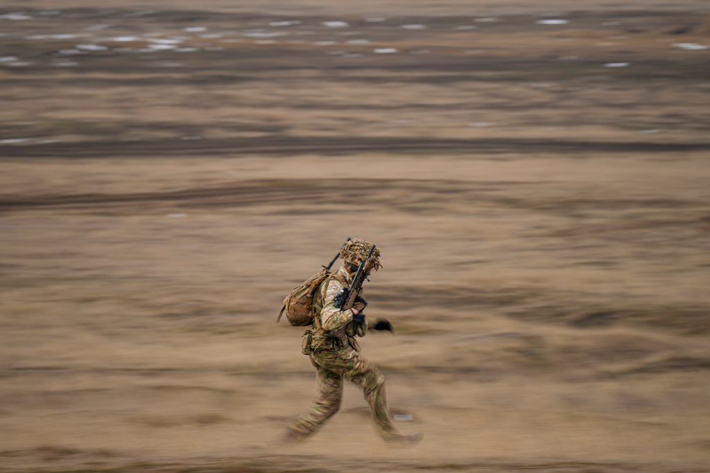 FILE - A British serviceman runs during the Steadfast Dart 2025 exercise, the largest NATO operation planned this year, at a training range in Smardan, eastern Romania, on Feb. 19, 2025. (AP Photo/Vadim Ghirda, File)