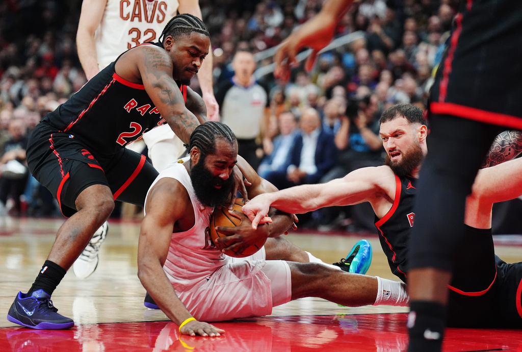 Toronto Raptors' Jamal Shead (left) and Sandro Mamukelashvili (right) battle with Cleveland Cavaliers' James Harden (1) for the ball during the first half of an NBA playoff basketball game in Toronto on Thursday, April 23, 2026. (Nathan Denette/The Canadian Press via AP)