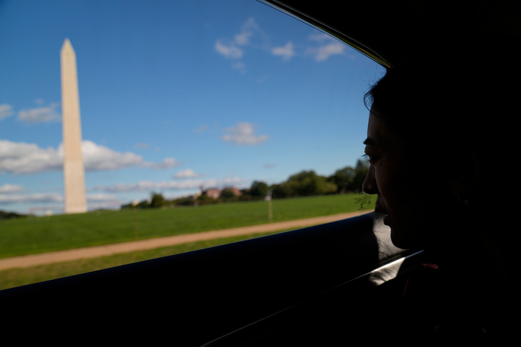 Namkyi, a Tibetan former political prisoner who was arrested at 15 for protesting Chinese rule, looks out toward the Washington Monument while driving to a meeting, Oct. 8, 2025, in Washington. (AP Photo/David Goldman)
