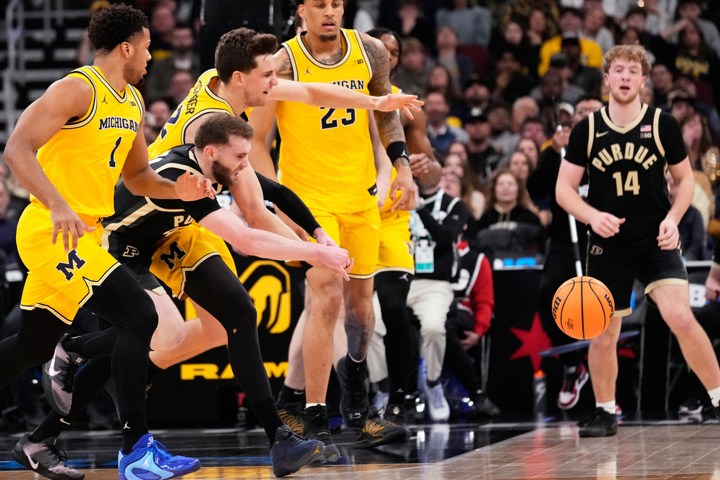 Purdue guard Braden Smith, second from left, and Michigan forward Will Tschetter, third from left, chase the ball during the first half of an NCAA college basketball game in the championship of the Big 10 Conference tournament, Sunday, March 15, 2026, in Chicago. (AP Photo/Nam Y. Huh)