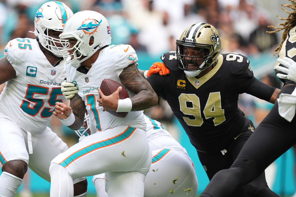 New Orleans Saints defensive end Cameron Jordan (94) grabs Miami Dolphins quarterback Tua Tagovailoa (1) for a sack during the first half of an NFL football game Sunday, Nov. 30, 2025, in Miami Gardens, Fla. (AP Photo/Rebecca Blackwell)