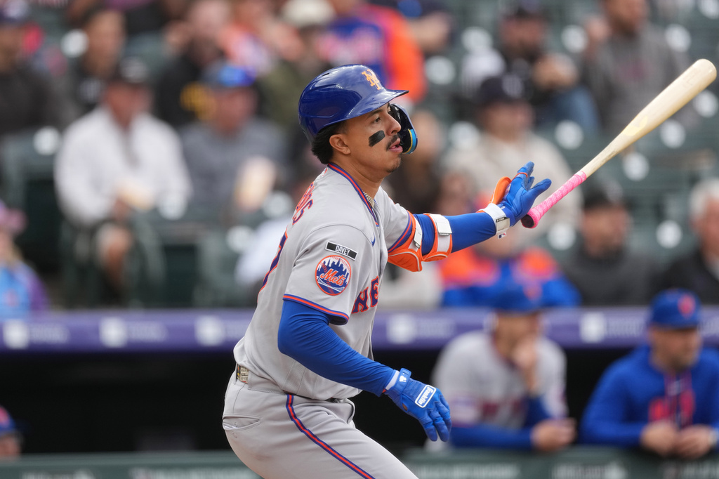 New York Mets' Mark Vientos follows the flight of his single to drive in two runs off Colorado Rockies relief pitcher Jaden Hill in the sixth inning of a baseball game Monday, May 4, 2026, in Denver. (AP Photo/David Zalubowski)
