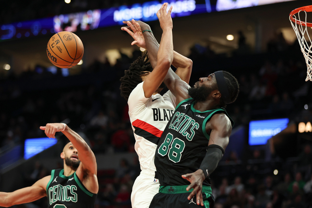 Portland Trail Blazers guard Shaedon Sharpe, center, and Boston Celtics center Neemias Queta, right, collide during the second half of an NBA basketball game Sunday, Dec. 28, 2025, in Portland, Ore. (AP Photo/Amanda Loman)