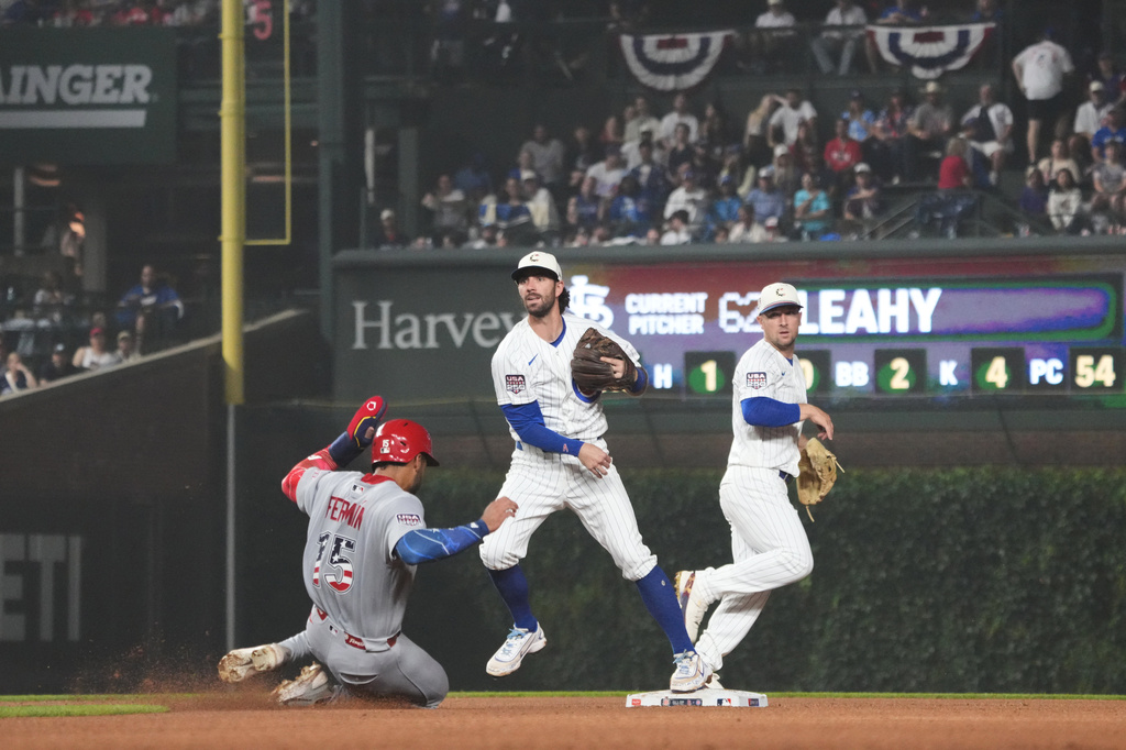 Chicago Cubs shortstop Dansby Swanson, center, throws to first base to complete a double play after forcing out St. Louis Cardinals José Fermín, left, at second base during the fourth inning of a baseball game Saturday, July 4, 2026, in Chicago. (AP Photo/David Banks)