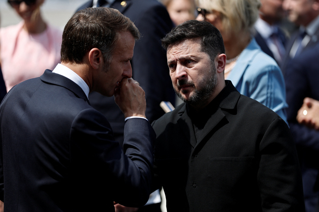 French President Emmanuel Macron speaks with Ukraine's President Volodymyr Zelenskiy as they leave after the annual Bastille Day military parade on the Place de la Concorde in Paris, France, Tuesday, July 14, 2026. (Benoit Tessier/Pool photo via AP)