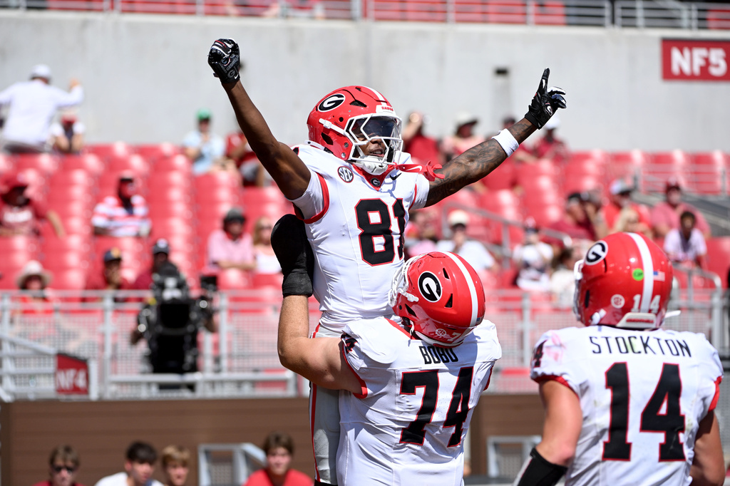 Georgia wide receiver Craig Dandridge (81) celebrates with teammates Drew Bobo (74) and Gunner Stockton (14) after a touchdown catch against Arkansas during the second half of an NCAA college football game Saturday, Sept. 19, 2026, in Fayetteville, Ark. (AP Photo/Michael Woods)