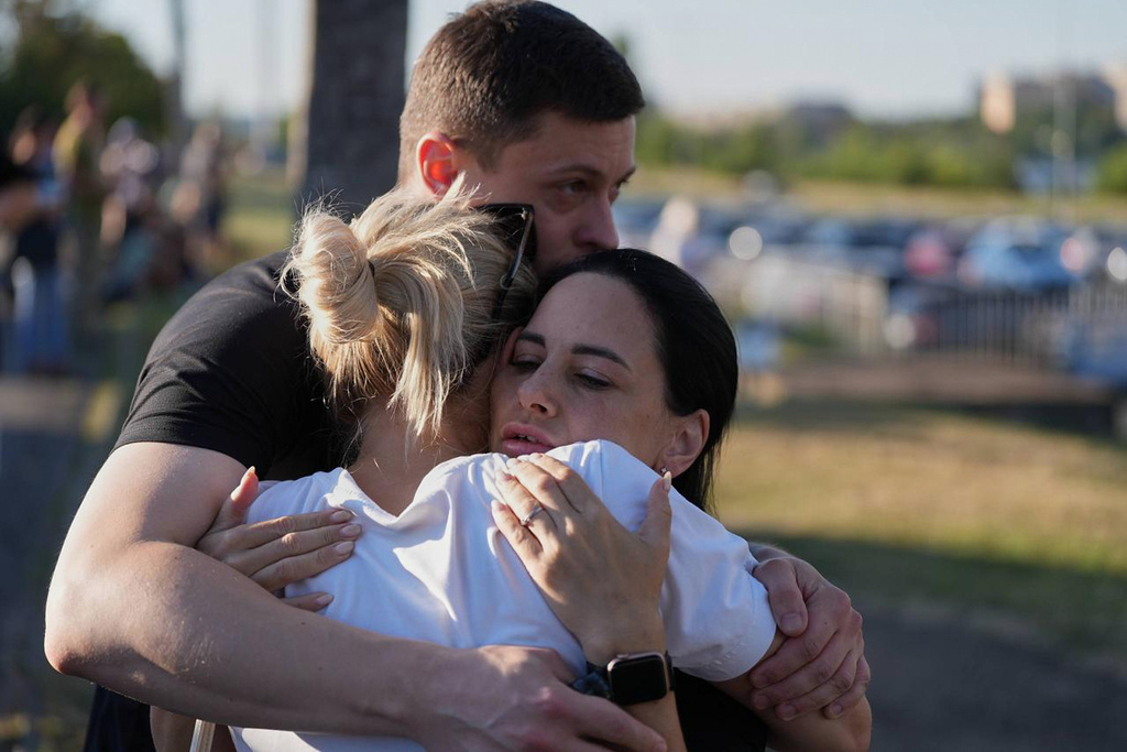 People embrace each other near a burning shopping mall following a Russian drone attack in Kryvyi Rih, Ukraine, Friday, Aug. 21, 2026. (AP Photo)