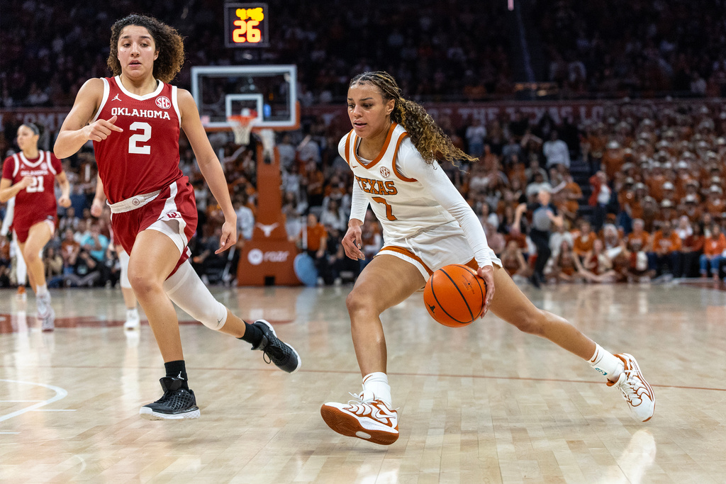 Texas guard Jordan Lee (7) drives past Oklahoma guard Aaliyah Chavez (2) during the second half of an NCAA college basketball game Sunday, Feb. 1, 2026, in Austin, Texas. (AP Photo/Stephen Spillman)