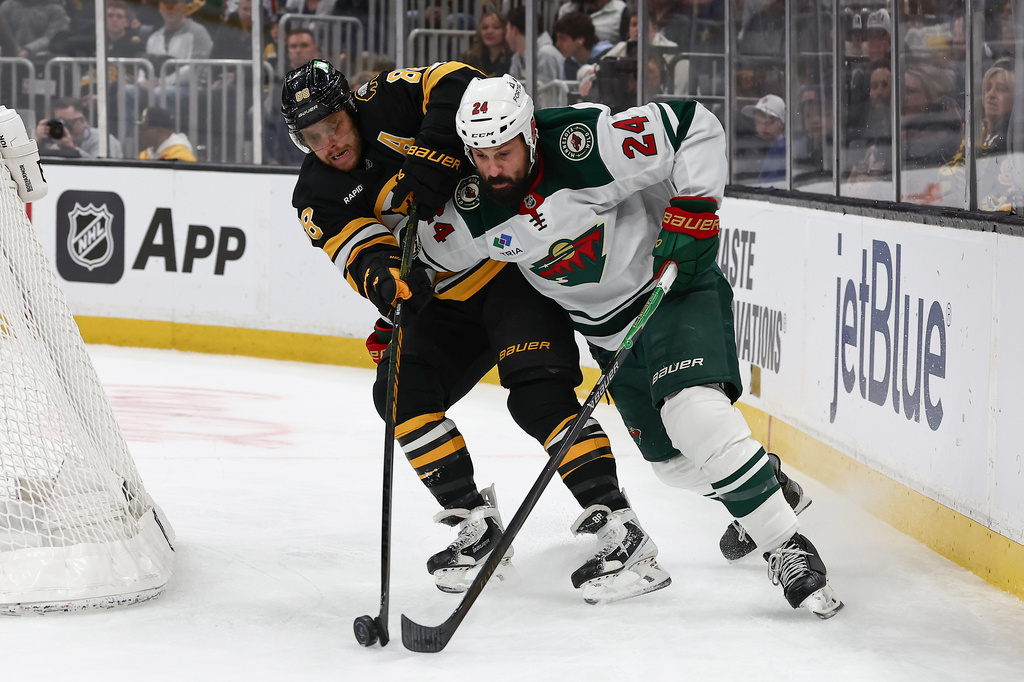 Minnesota Wild's Zach Bogosian tries to hold off Boston Bruins' David Pastrnak during the second period of an NHL hockey game Saturday, March 28, 2026, in Boston. (AP Photo/Winslow Townson)
