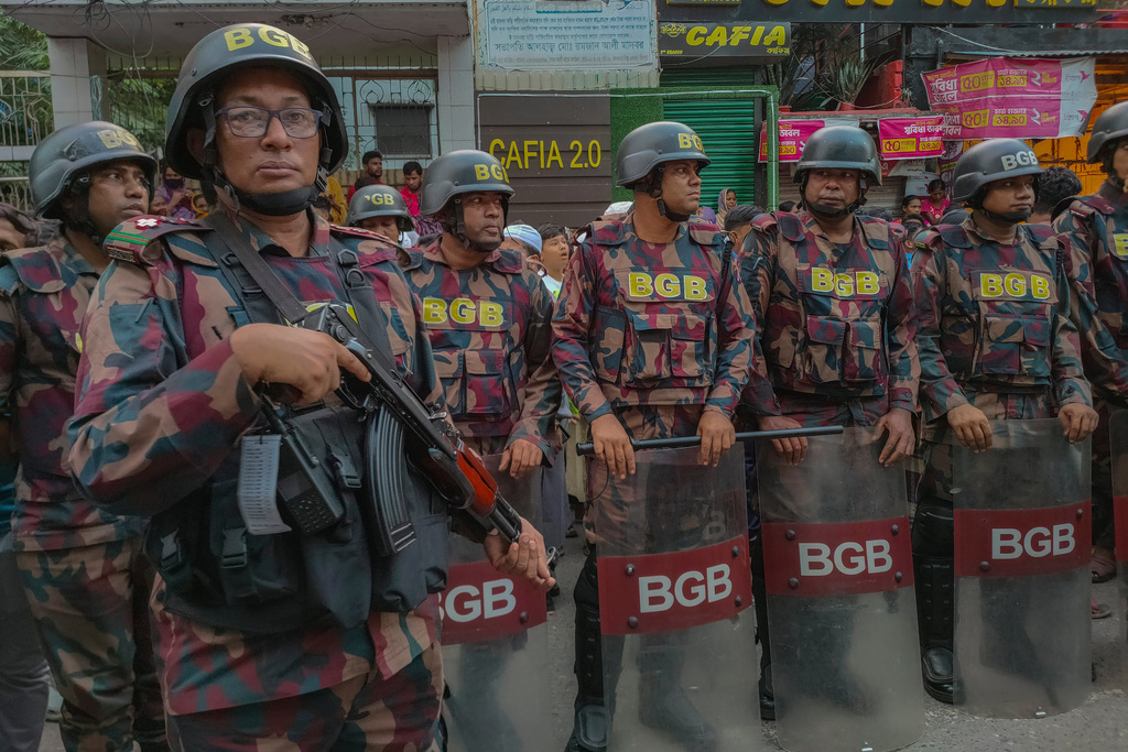 Members of the Border Guard Bangladesh stand at the site after a fire broke out at a chemical warehouse and garment factory in Mirpur, Dhaka, Bangladesh, on Tuesday, Oct. 14, 2025. (AP Photo/Mahmud Hossain Opu)
